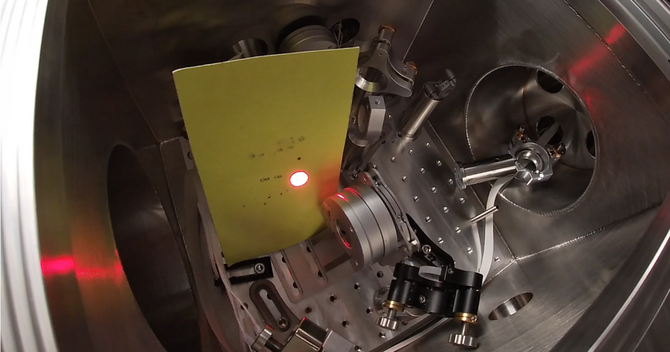 Vacuum chamber with optical components and a laser. Photo.